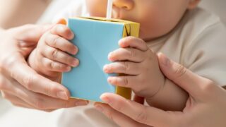 ストローの刺さった紙パックを持つ親子